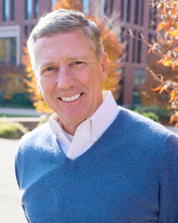Joachim smiling for a headshot in front of the Learning Innovation Center