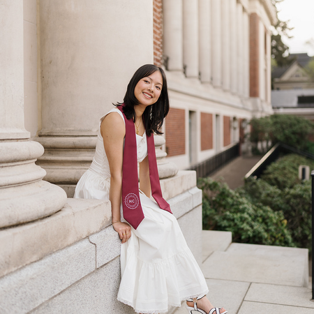 Prongbaramee smiles while sitting outside of the Memorial Union, wearing a Honors College stole.