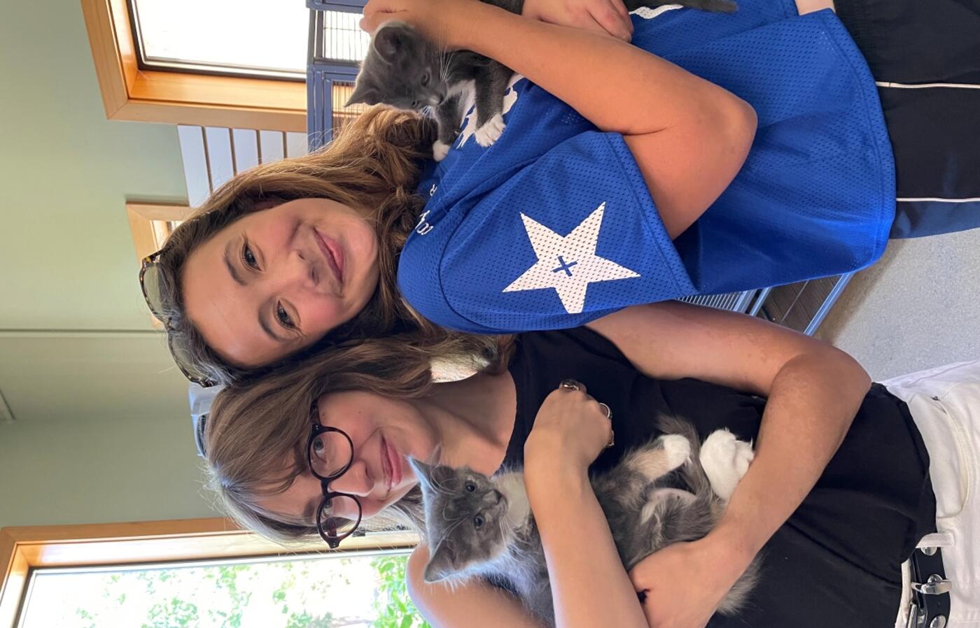 Kallie holding a kitten while posing.