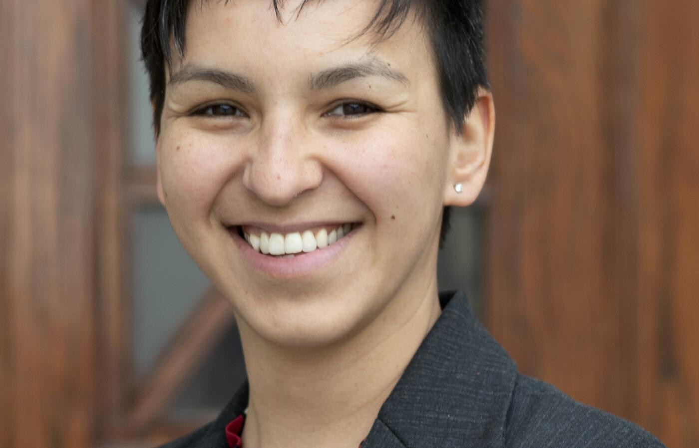 Tari Tan smiling in a dark gray suit.