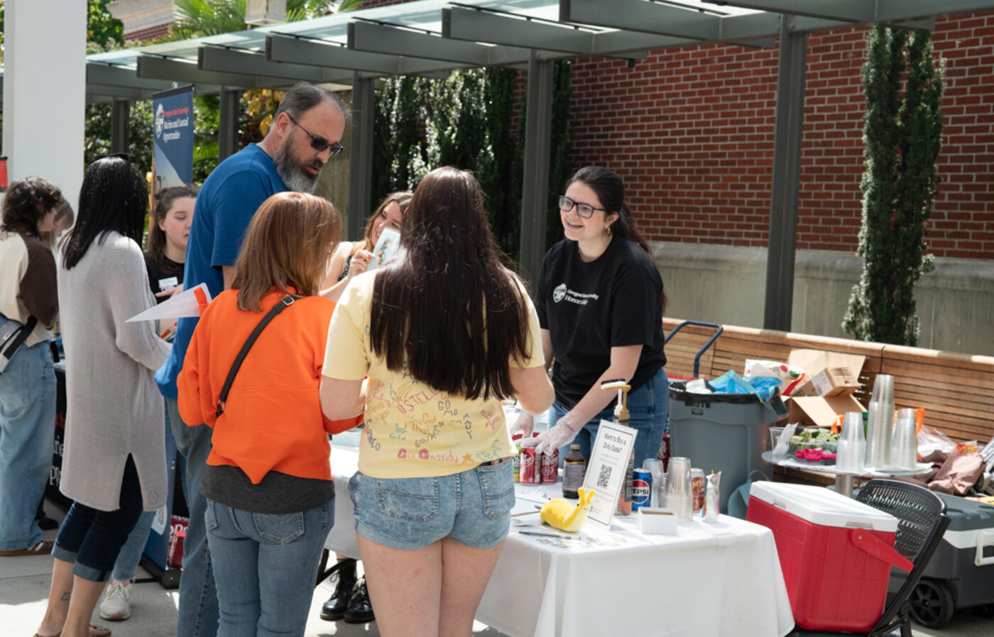 Honors student engages community members at the Honors College table during the Dam Proud Day Street Fair, where honors students sold dirty sodas to raise funds for HC student scholarships.