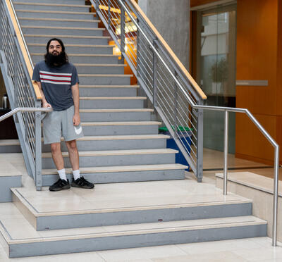 Adrian Baker standing at the stairs of the Kelley Engineering Center