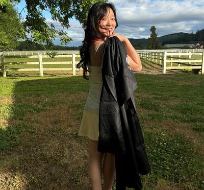 Kaitlyn smiling in her grad robes
