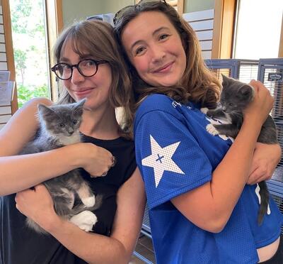Kallie posing while holding a kitten.