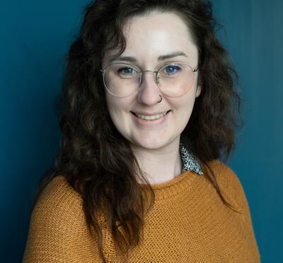 Shannon smiling with a blue backdrop
