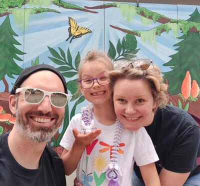 Megan, her husband, and her daughter all smiling.