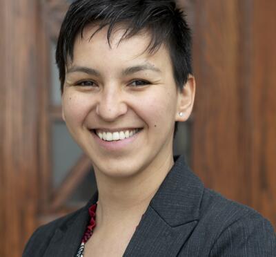 Tari Tan smiling in a dark gray suit.