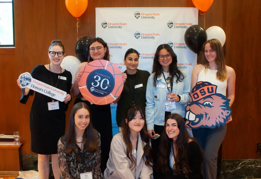 Katelyn holding an OSU Honors College banner with other students.