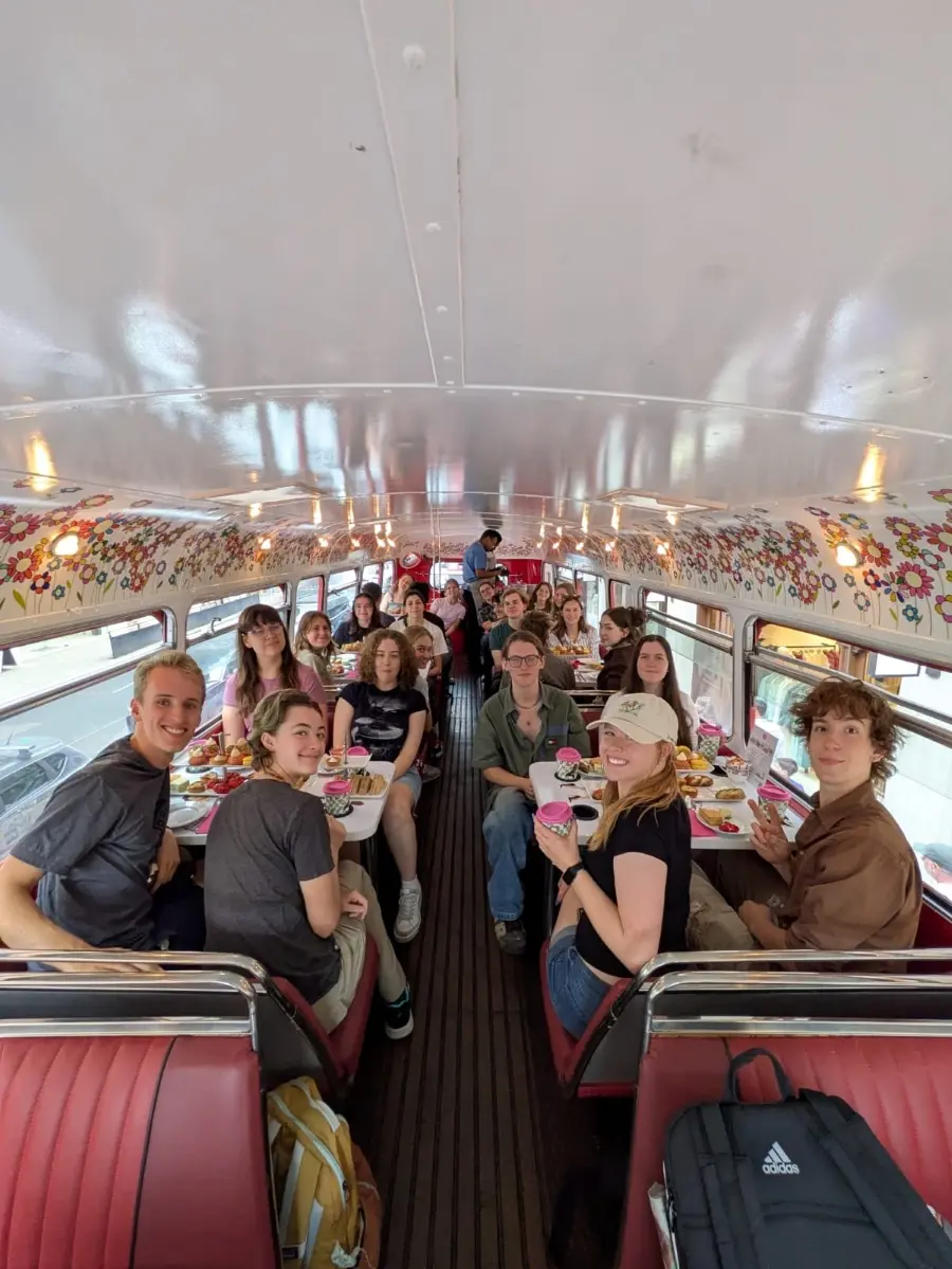 Students and faculty in the 2025 HC London program enjoy a traditional tea time and a top view of London traffic from their perch on a double-decker bus. 