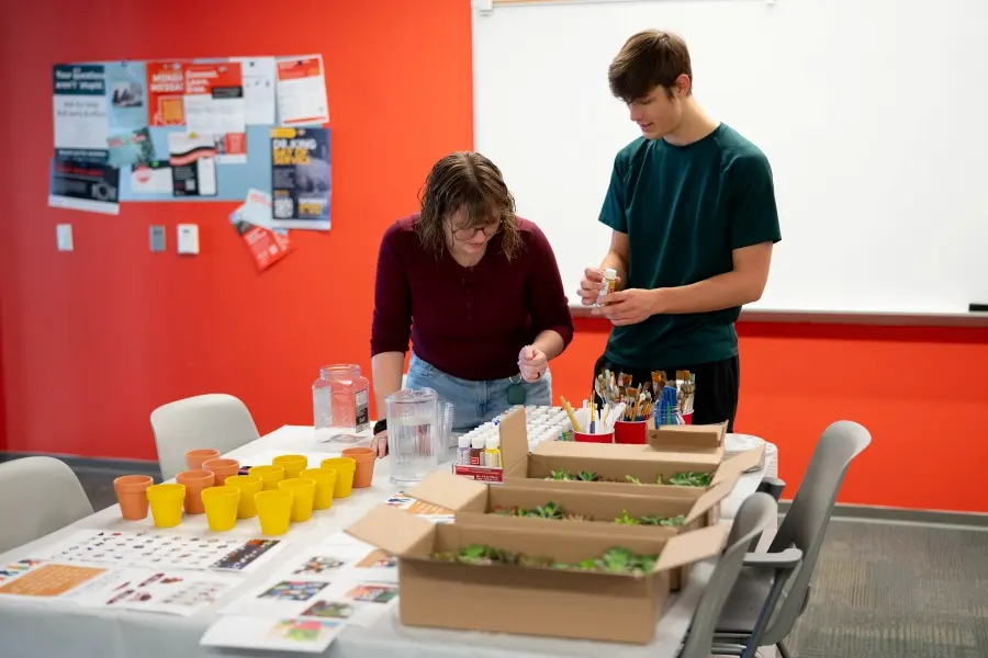 Two HC Students picking out paints for their succulent pots.