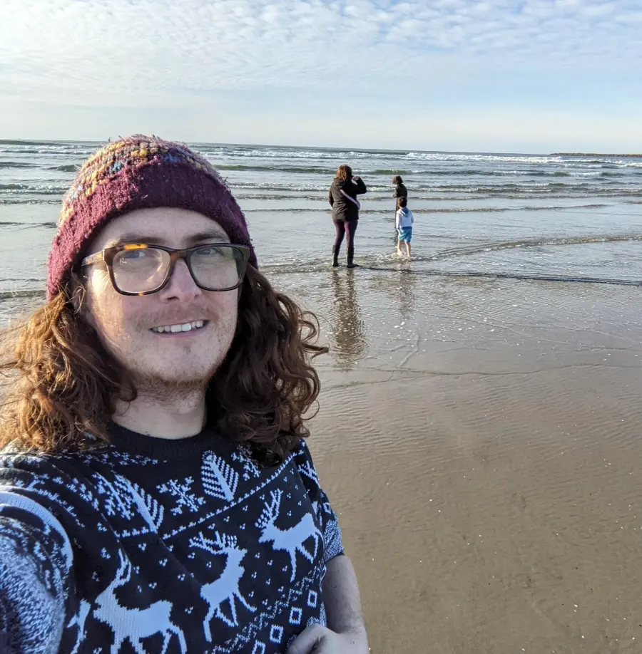 Dewi taking a selfie with his family in the background.