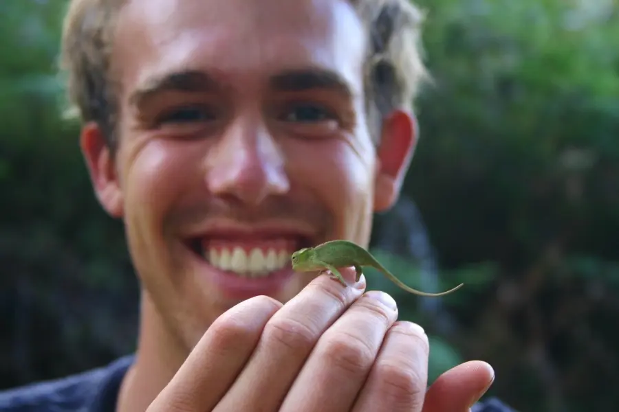 Dylan smiling with a lizard sitting on his hand.