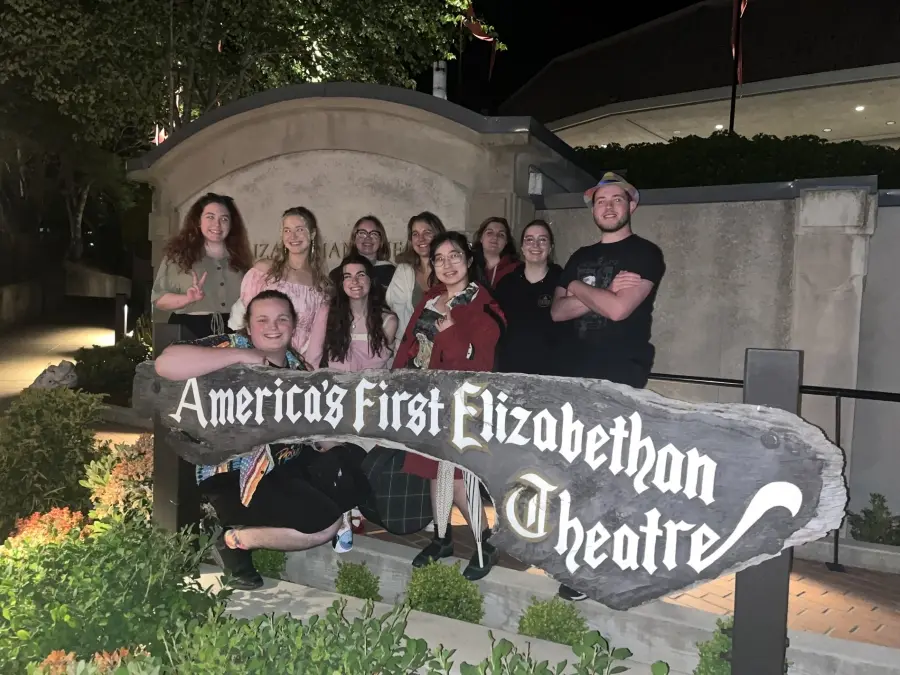 Students from Theatre in Ashland seminar course smiling in front of a sign for the America's First Elizabethan Theatre.