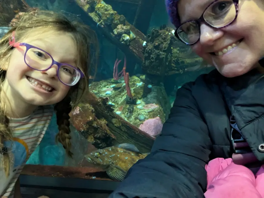 Megan and her daughter at an aquarium.