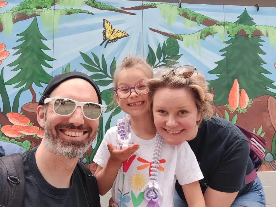 Megan, her husband, and her daughter all smiling.