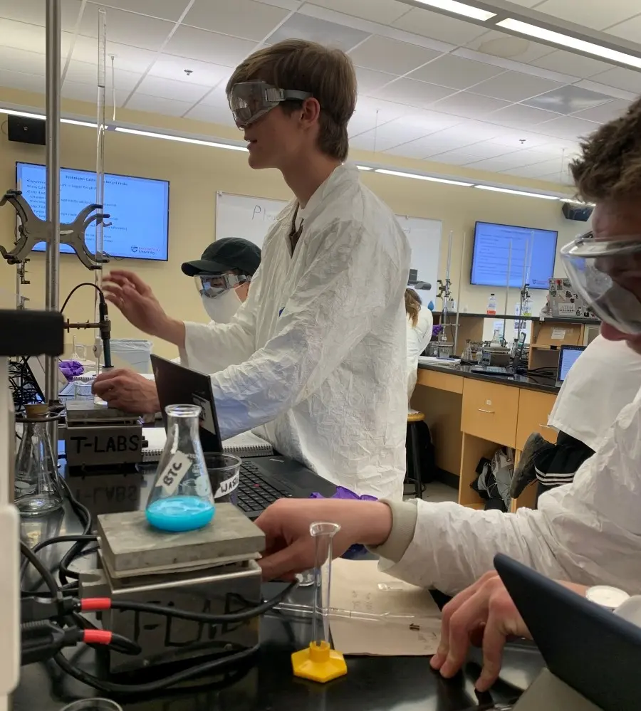 Honors general chemistry students working at a lab station.
