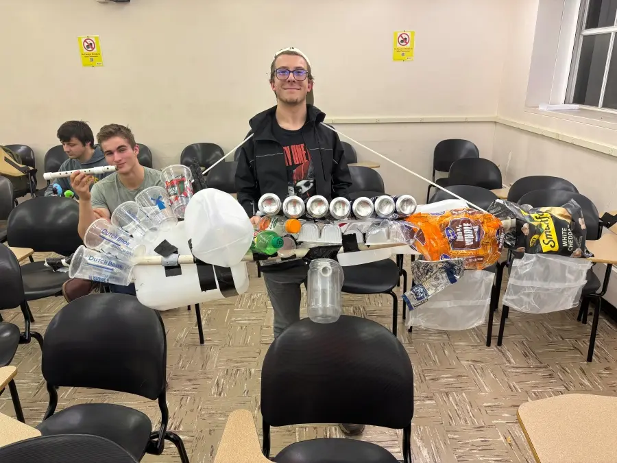  A Plastics for Poets student poses for a photo with a plastic drumset.
