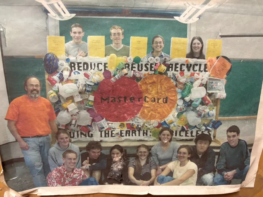 Skip Rochefort and students in one of the original sections of his Plastics for Poets seminar smiling with a MasterCard out of plastic waste.