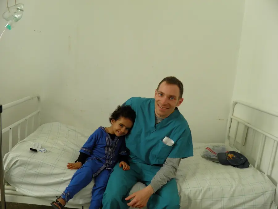 Brian Wilkinson with a patient while volunteering abroad.
