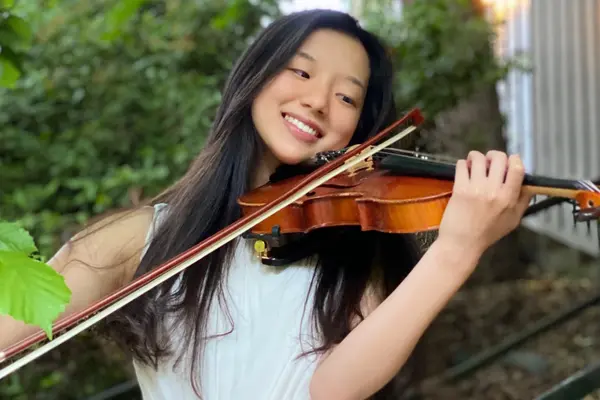 Kaitlyn Kim smiling and playing a violin