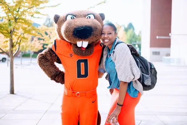 Tenisha Tevis smiling next to Benny Beaver