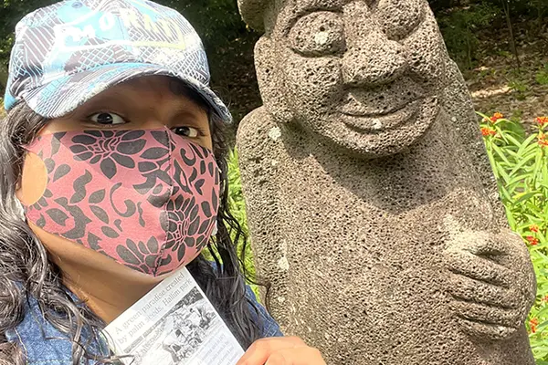 Andrea takes a selfie in front of a statue 