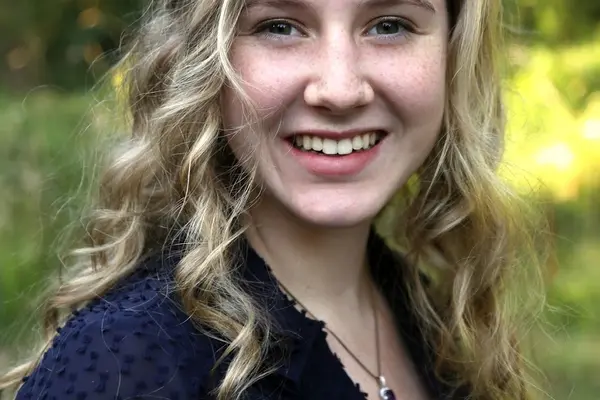 Grace Knutsen smiling with trees behind her