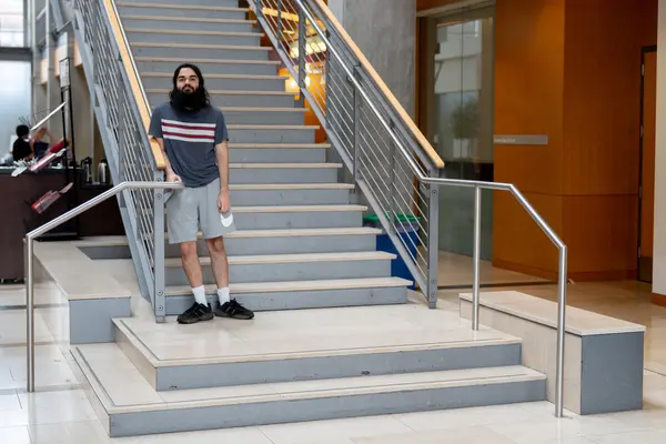Adrian Baker standing at the stairs of the Kelley Engineering Center