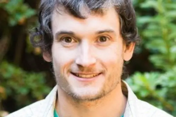 Dr. Nathan Kirk smiling in front of a tree