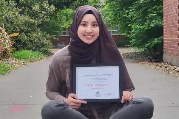Bushra smiling with their degree