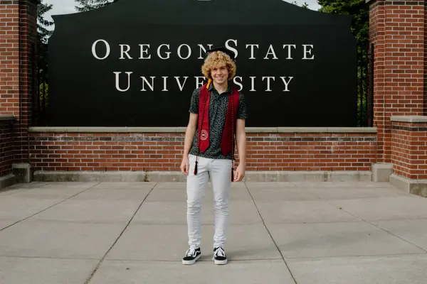 Seth Thomas in his graduation cap, stole, and cords