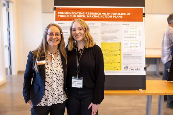 Margaret Martin and her mentor Dr. Lipscomb in front of Martin's poster presentation for the Cascades Research and Scholarship Symposium 2024.