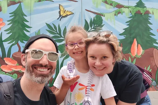 Megan, her husband, and her daughter all smiling.